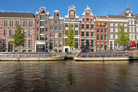 Medieval houses and cruise boats in the city center from Amsterdam in the Netherlands