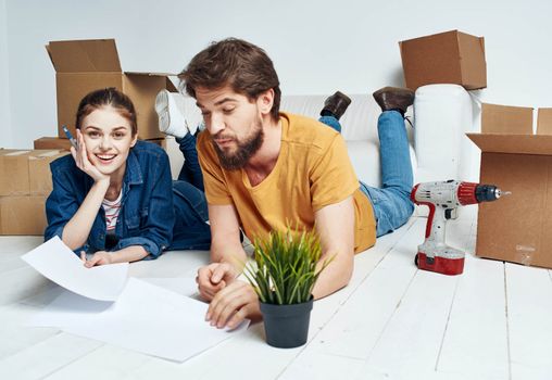 man and woman on the floor with boxes planning moving to apartment. High quality photo