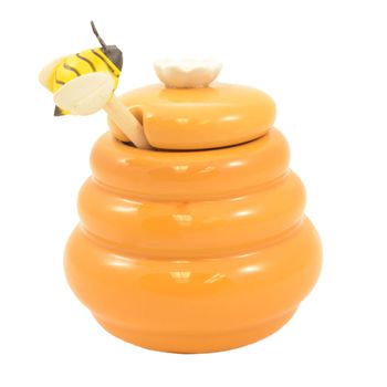 An isolated over a white background image of a golden honey pot and dipper stick.