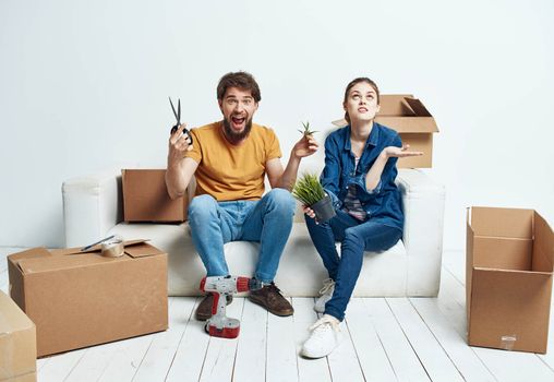 Young couple with boxes of things tools room interior. High quality photo