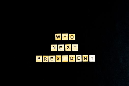 The phrase Who is the next American President - with an American flag in the background. A new election race in the United States. Primary. Candidates. Politics. Government. Force. flatlay, top view.