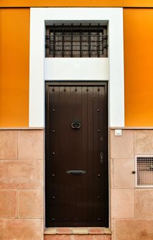 Colorful brown wooden door with iron details in Lisbon, Portugal
