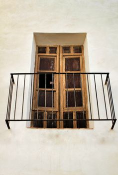 Old house white facade with rusty broken balcony in Spain