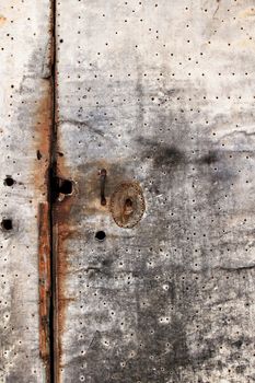 Old rusty and damaged metal door of a Spanish house