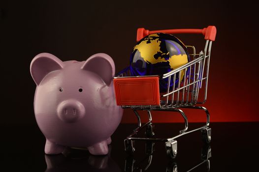 A concept based on globalized shopping accounts with a pig bank and globe and grocery cart.
