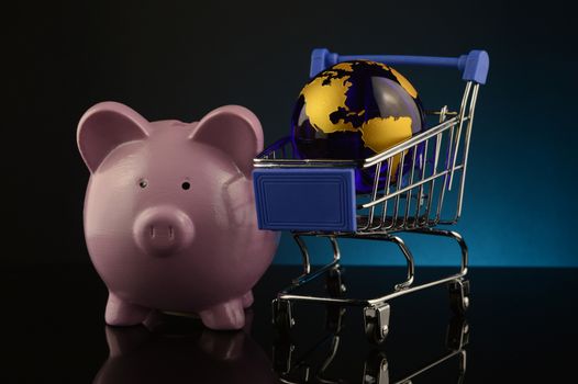 A concept based on globalized shopping accounts with a pig bank and globe and grocery cart.