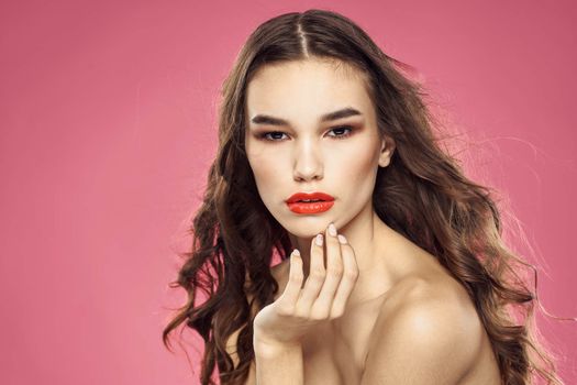 Beautiful woman with red lips on a pink background nude shoulders cropped view. High quality photo