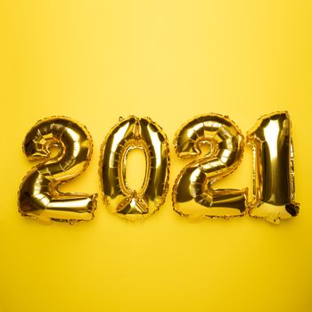2021 concept new year from golden foil balloon on yellow stock photo