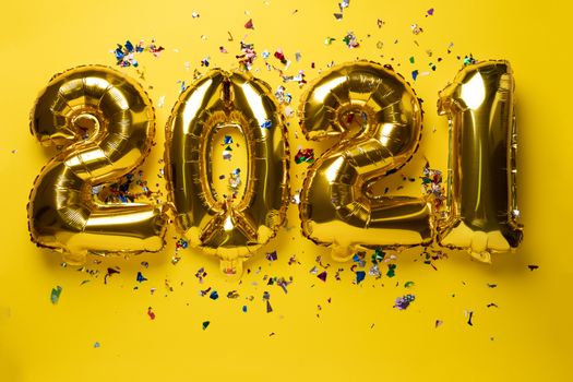 2021 numbers for new year from golden foil balloon and confetti stock photo