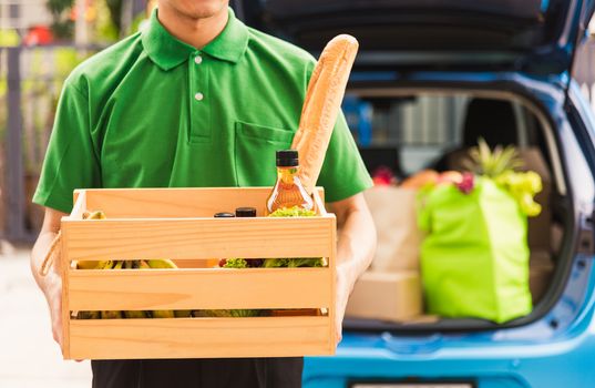 Asian delivery man grocery prepare service giving fresh vegetables food and fruit full in wooden basket on back car to send woman customer at door home after pandemic coronavirus, Back to new normal