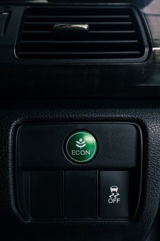 econ button on dashboard of modern car, press the button to switch to a setting that saves energy and to improving fuel efficiency, shallow depth of field