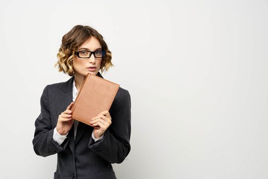 Business woman with notepad and glasses work light background cropped view of suit model. High quality photo