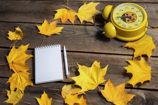 .Autumn fallen leaves and office supplies on wooden background