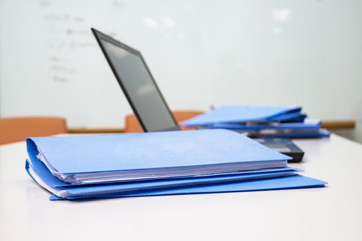 Blue Document folder on table at office with laptop background