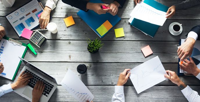 Business corporate management planning team concept, people sitting around office table and working with financial data reports