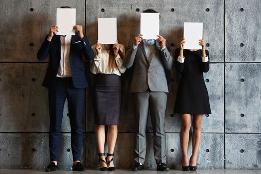 People holding blank papers with white copy space for text or letters content , hiding faces