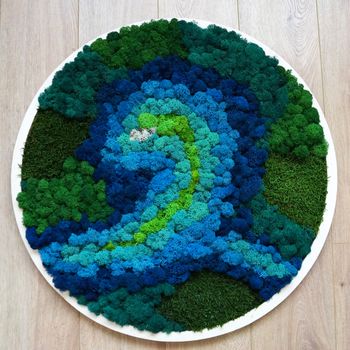 round panel from colored stabilized moss on a wooden background.