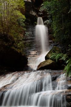 Waterfall flowing out of a canyon into a gorgw ravine in Blue Mountains