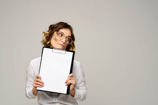 Business woman in a light shirt and a folder with documents in hands cropped view of work. High quality photo