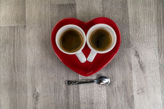 two teaspoons of coffee with a heart-shaped saucer and a teaspoon