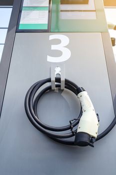 power supply connecter to plug-in electric vehicle or electric car at charging station in car park area of shopping plaza. charging technology for future automotive and city life.