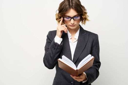 Business woman with notepad and glasses work light background cropped view of suit model. High quality photo