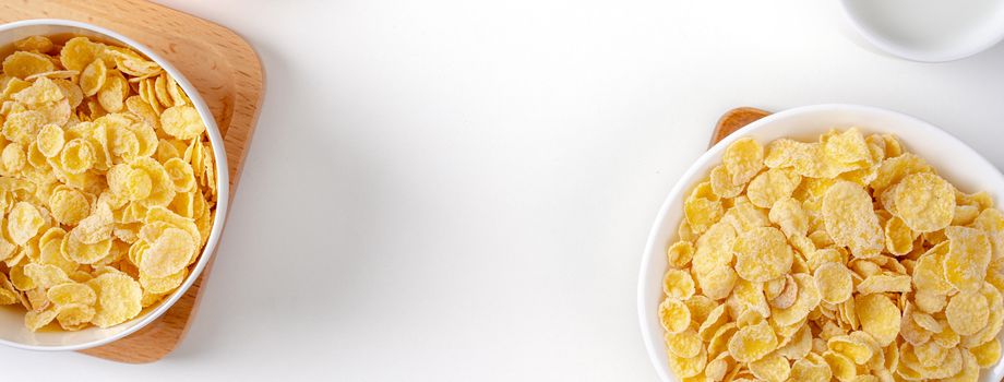 Top view of corn flakes bowl sweeties with milk and orange on white background, flat lay overhead layout, fresh and healthy breakfast design concept.