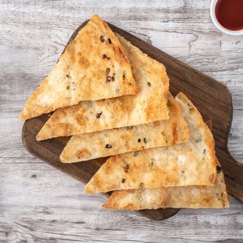 Taiwanese food - delicious flaky scallion pie pancakes on bright wooden table background, traditional snack in Taiwan, top view.