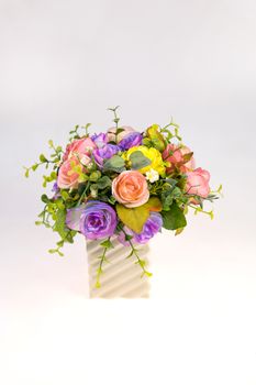 Vase plastic flowers in the room isolated on white background.