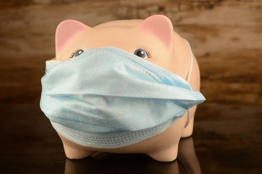 A masked piggy bank for financial crisis concepts related to the covid coronavirus pandemic.