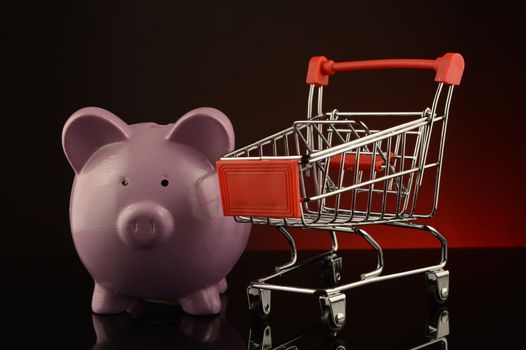 A piggy bank and shopping cart to illustrate sales concepts.