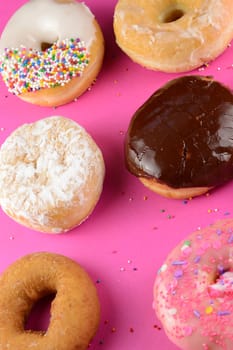 An overhead view of six various donuts that have been freshly baked and are ready to be consumed.