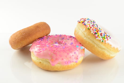 An assortment of various fresh donuts over a white background.