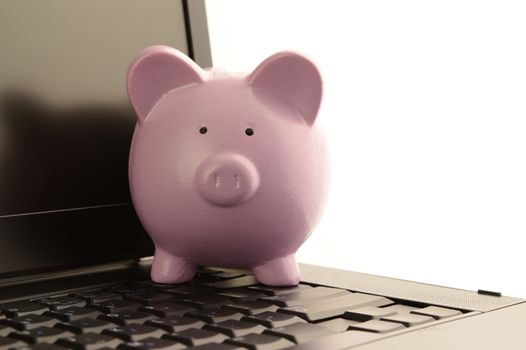 A piggy bank on a laptop for online financial services.