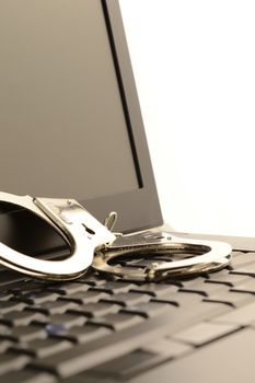 A set of handcuffs and laptop to represent internet police work.