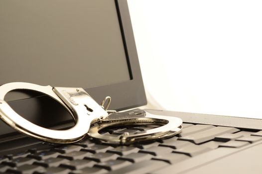 A set of handcuffs and laptop to represent internet police work.