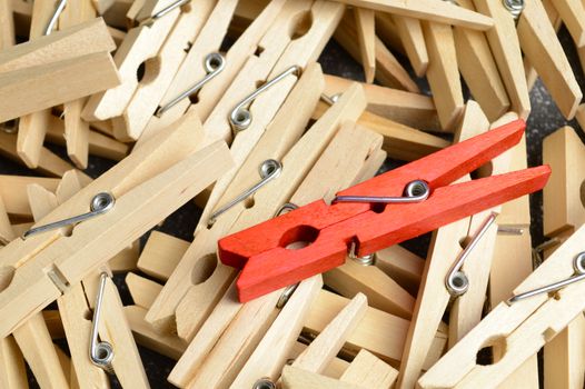 A unique red clothespin stands out from the rest.