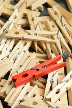 A unique red clothespin stands out from the rest.