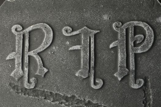 Closeup of a gravestone with the words RIP rest in peace.