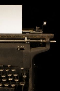 An antique typewriter with a blank piece of paper.