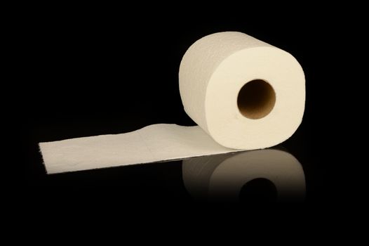 A toilet paper rolling on a reflective black surface.