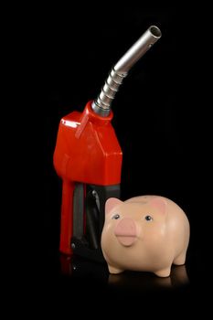 A red gas pump nozzle with a pig bank for various concepts.