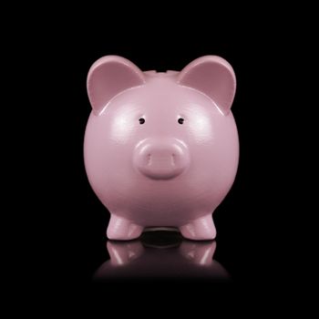 An isolated over a black background image of a pink piggy bank for saving coins.