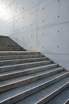 Grey granite stairs in front of a concrete wall