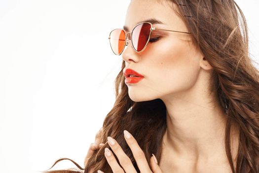 Portrait of brunette woman in sunglasses naked shoulders light background. High quality photo