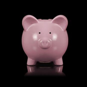 An isolated over a black background image of a pink piggy bank for saving coins.