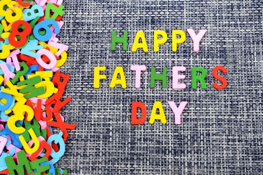 A childish creation of writing a Happy Fathers Day message using wooden alphabet letters.