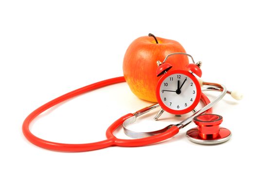 A red apple with an alarm clock and stethoscope over a white background to represent medical themes.
