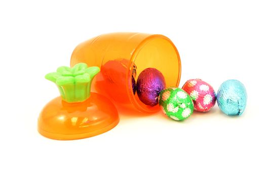 Some festive ways to store Easter candy inside a cute carrot container isolated over white.