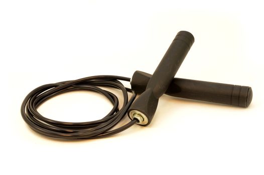 An isolated shot of a black skipping rope over a white background.